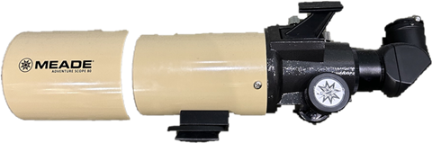 A cream Meade refractor telescope